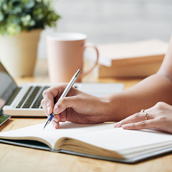 person writing in notebook